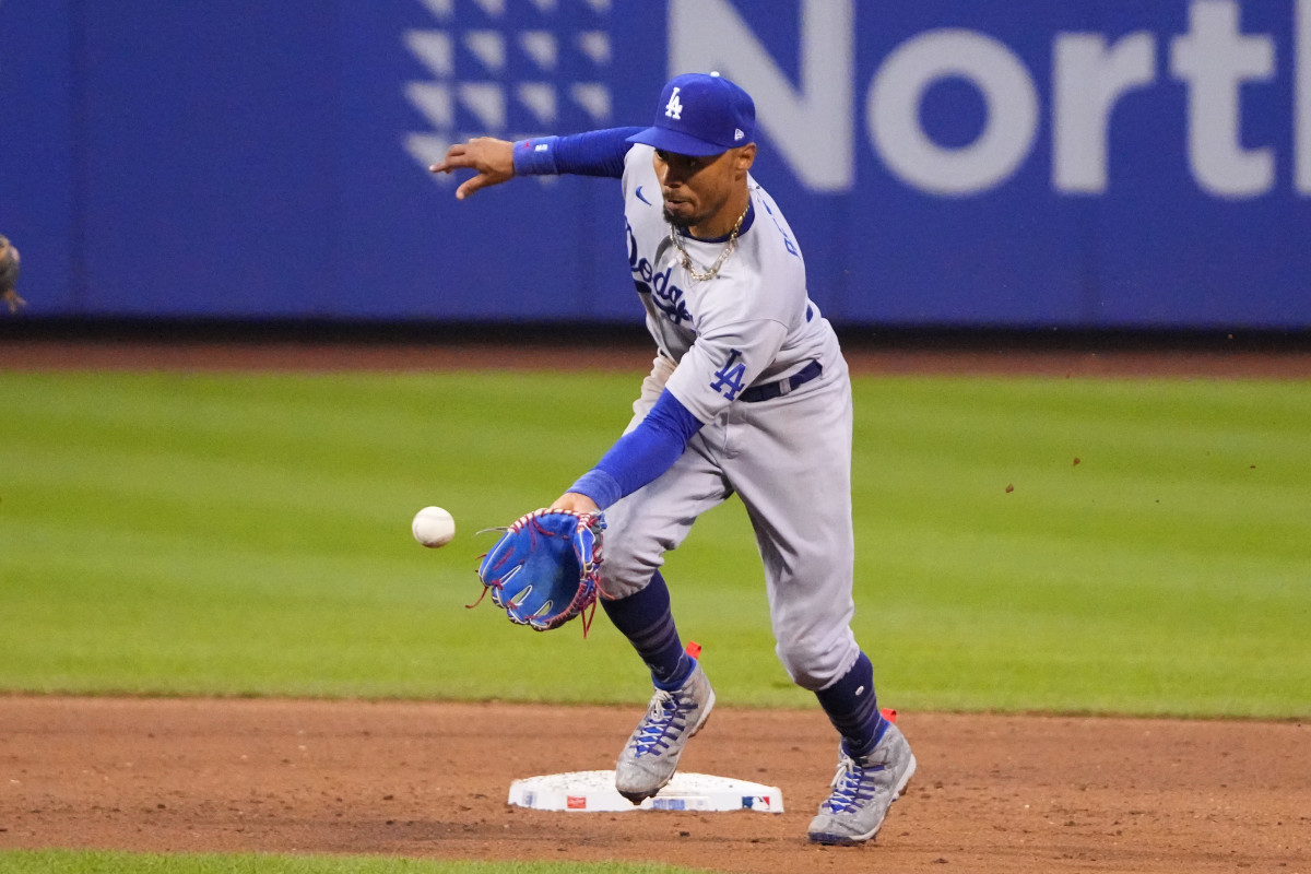Mookie Betts puts his glove toward the ground to try to field a ball flying toward him